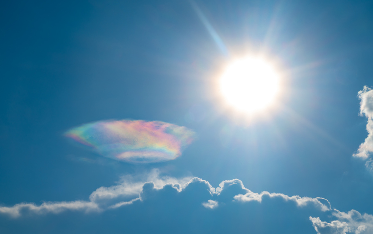 Beautiful Iridescent clouds appear on the sky nearly the sun.