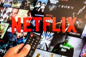 In this photo illustration a close-up of a hand holding a TV...