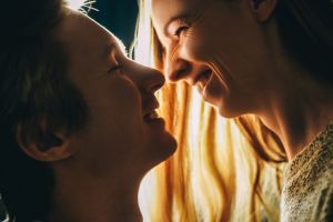 Young couple have fun in love in dark with back lit close-up.