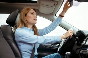 Woman Driver Adjusting Rear View Mirror in the Car