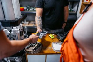 Young Couple Paying Via Credit Card In A Moto Shop