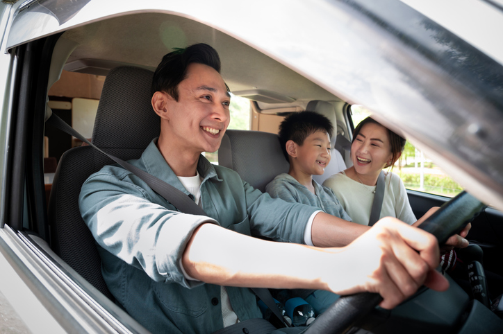Joyful Asian family enjoying holiday vacation with their camper van