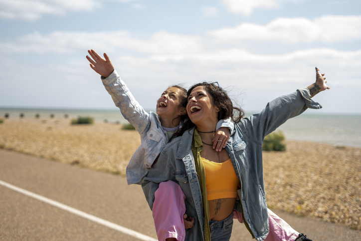 Smiling mother giving daughter (8-9) piggyback ride