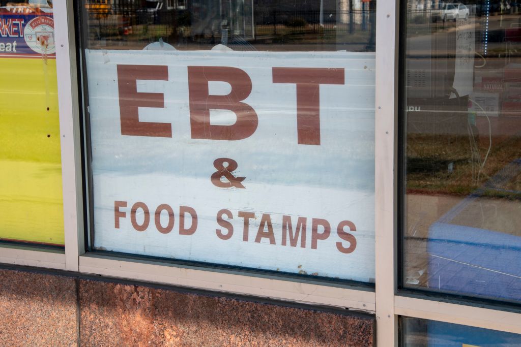 Grocery store with sign in window accepting Electronic benefit transfer cards and food stamps.
